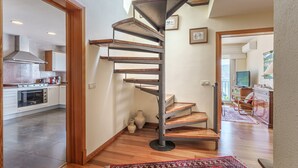 Une cuisine moderne dotée d’un four encastré et d’un escalier en colimaçon menant à un niveau supérieur.