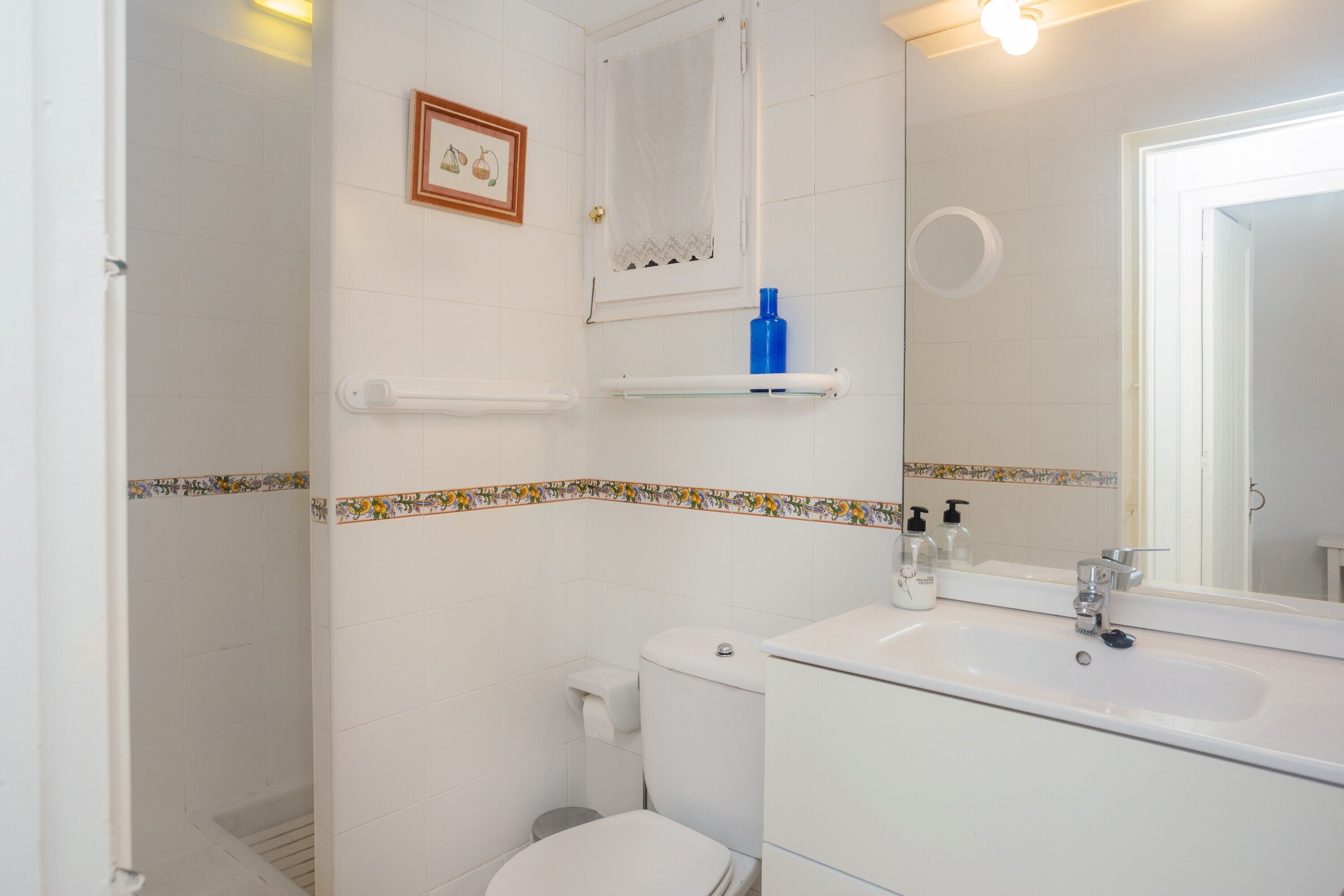 A bathroom with a toilet, sink, and shower.