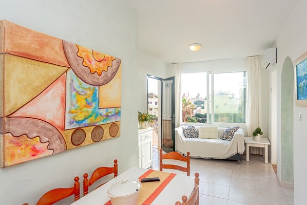Un comedor con una mesa, sillas y un cuadro en la pared.