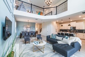 Relax in this stylish living area with a mezzanine level, sofa, coffee table, and dining space.