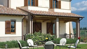 A two-story house with a patio area featuring outdoor seating and a view of the mountains. - Villa Ornata B: A characteristic and welcoming apartment surrounded by the greenery, with Free WI-FI. (Cannara)