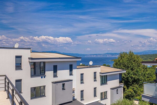 A modern building with multiple balconies overlooking a coastal area.