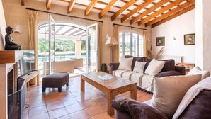 A spacious living room with a wooden ceiling, a sofa set, a coffee table, and a fireplace. - Finca Na Bona · Finca Na Bona. Perfect location. Menorca (Mahón)
