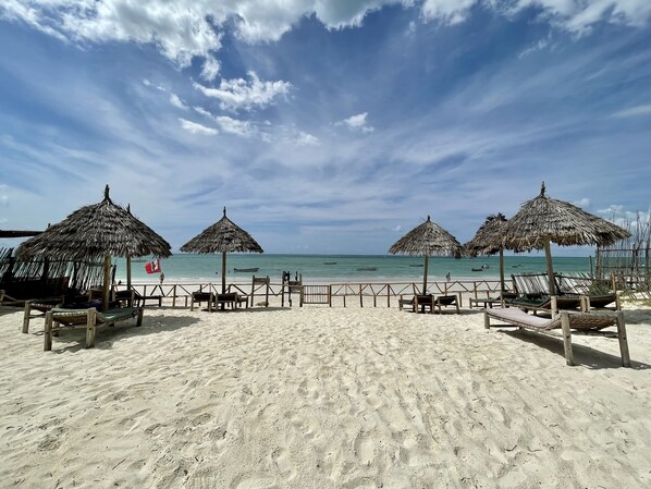 Privatstrand, weißer Sandstrand, Liegestühle, Sonnenschirme