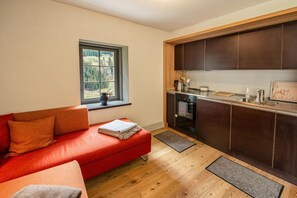 Cozy living space with a sofa, kitchenette, and window view of the surrounding landscape.