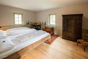 Cozy retreat with a large bed, wooden cabinet, and desk area.