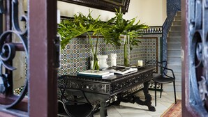 A dining area with a table, chairs, a mirror, and a decorative plant. - Villa Alfonso, Luxurious restored palace house next to Plaza de España. (Sevilla)