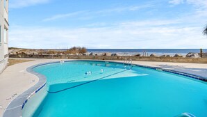 Una piscina con vista a la playa y al océano.