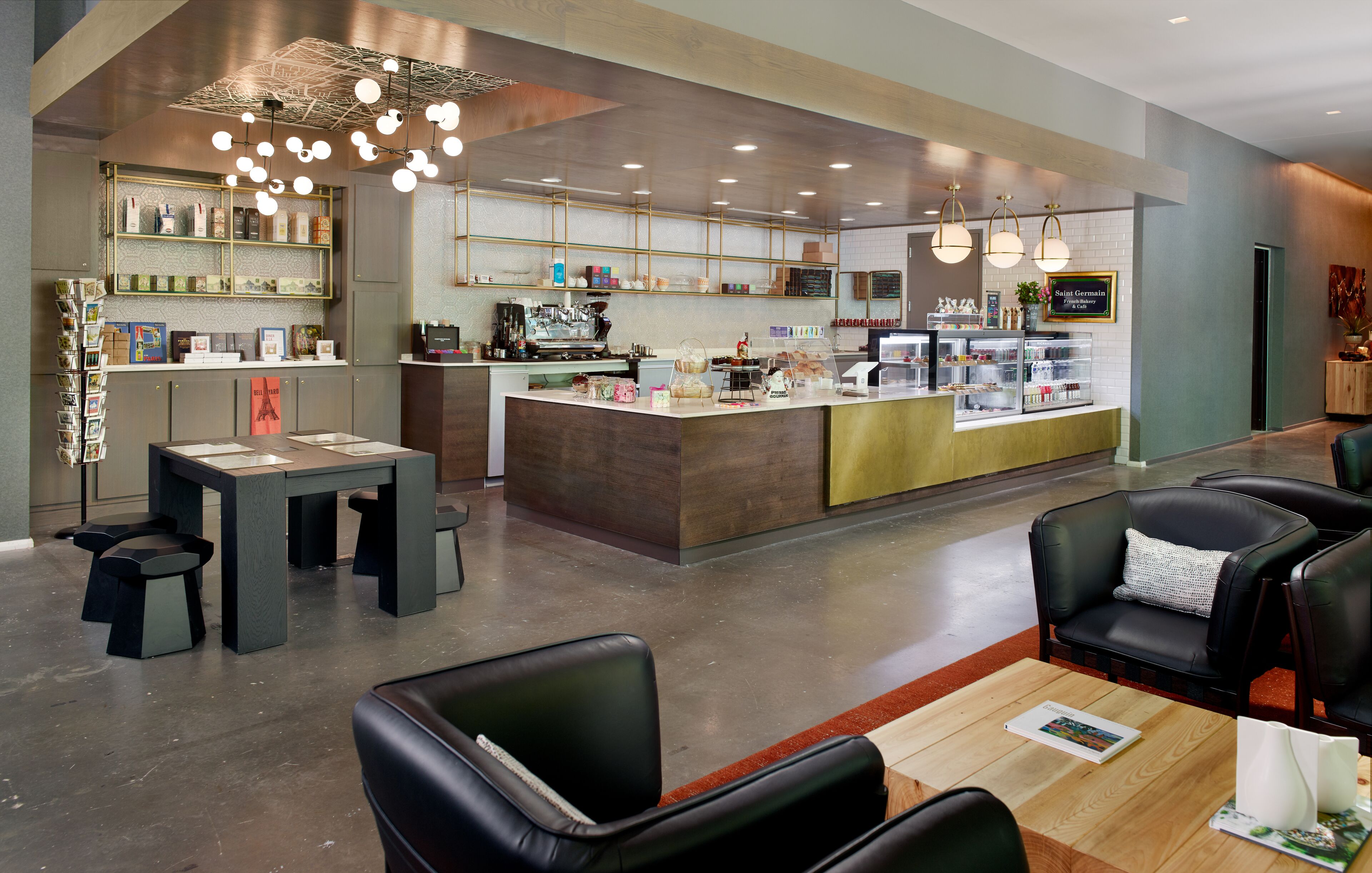 Una cafeteria moderna amb una barra central, zona de seients i una màquina de cafè.