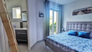 Een slaapkamer met een bed, een raam en een badkamer.