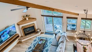 A spacious living room with a fireplace, a large TV, a sofa, and a dining table. - 2 Bedroom in Tarn Landing in Frisco (Frisco)