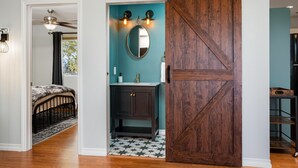 A bedroom with a bed, a ceiling fan, and a view of the outdoors. - Vineyard Views + Gourmet Kitchen | Paso Robles CA | 46 West Walnut Hill (Paso Robles)