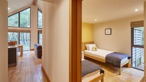 Un dormitorio con cama, mesita de noche y ventana.