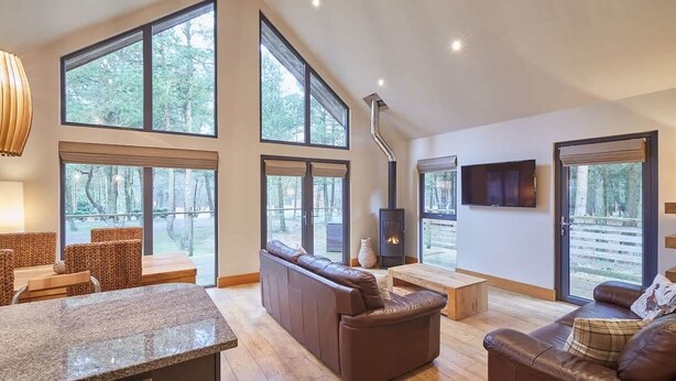 Amplia sala de estar con ventanas grandes, chimenea y encimera de piedra.