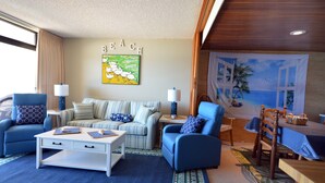 A living room with a sofa, chairs, a coffee table, and a dining area with a table and chairs. - Enjoy beautiful oceanfront views of the Ocean City coastline in this one bedroom, one bath condo located just a few steps from the beach! (Ocean City)