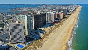Eine Küstenstadt mit Hochhäusern, einem Sandstrand und blauem Himmel.