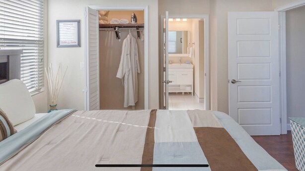 Une chambre à coucher avec un lit, une armoire et une porte ouverte donnant sur une salle de bain.