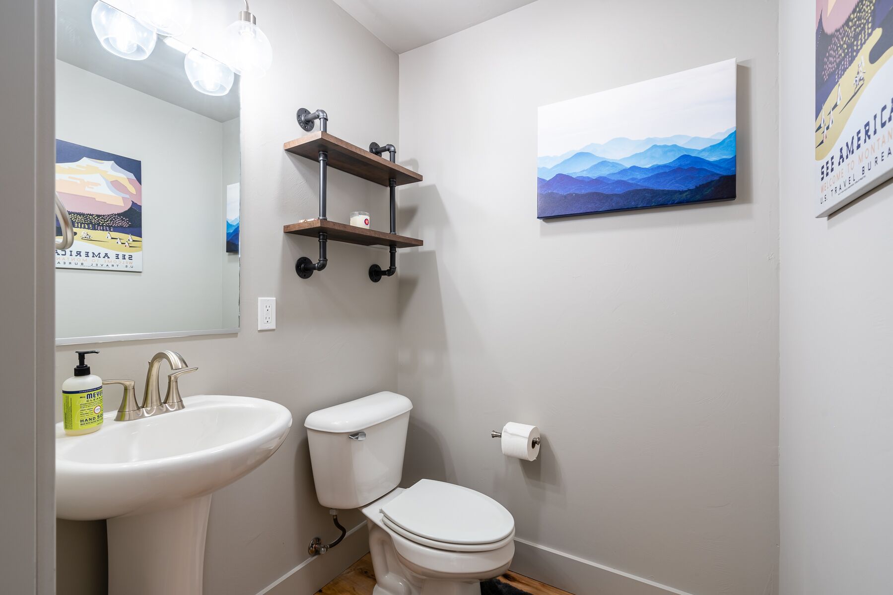 A bathroom with a white sink, toilet, and a shelf with toiletries.
