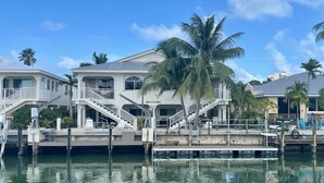 A waterfront property with multiple levels, outdoor seating, and a dock.