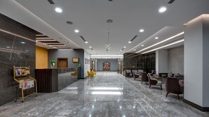 A modern lobby with a marble floor, reception desk, seating area, and a view of the reception. - Abar Hotel Apartments (Dubai)
