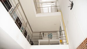A multi-level interior with metal railings, a fire extinguisher, and a visible emergency exit sign. - Ayenda Quimbaya de Oro 1903 (Armenia)
