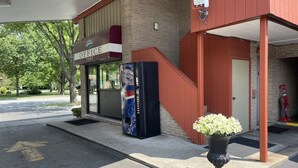 A building with a sign reading "OFFICE 7307" and a staircase leading to an entrance. - VIBE INN - WHIRLPOOL SUITES (Lyons)