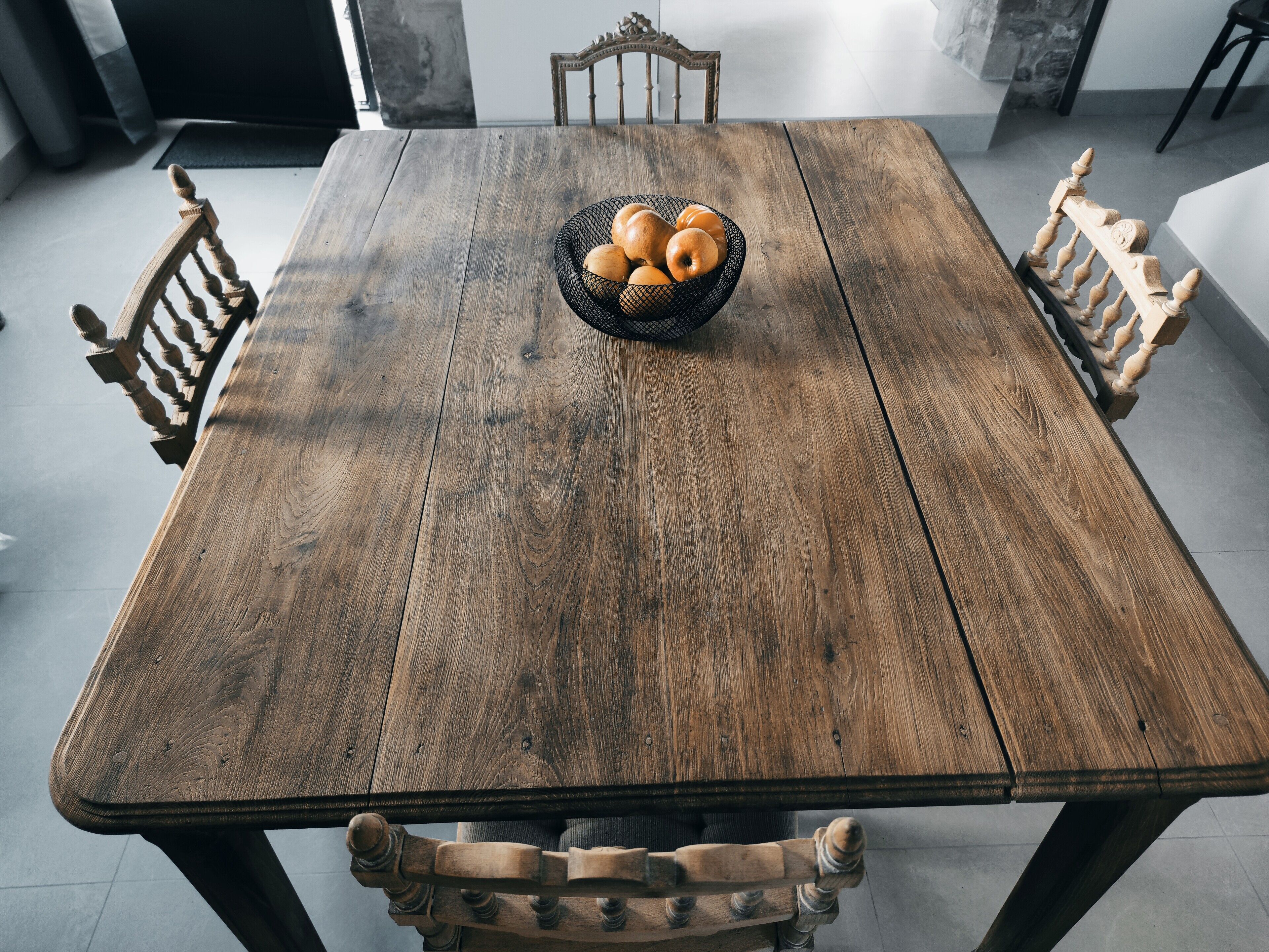A wooden dining table with a basket of bread.