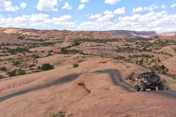 A rugged outdoor landscape with a vehicle on a rocky terrain.