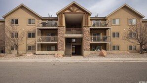A multi-story building with a central entrance, balconies, and a stone facade. - RedCliff Haven - Pool - HotTub - Aug availability (Moab)