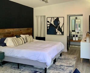 Relax in a stylish space with a large bed, wooden headboard, and abstract art.