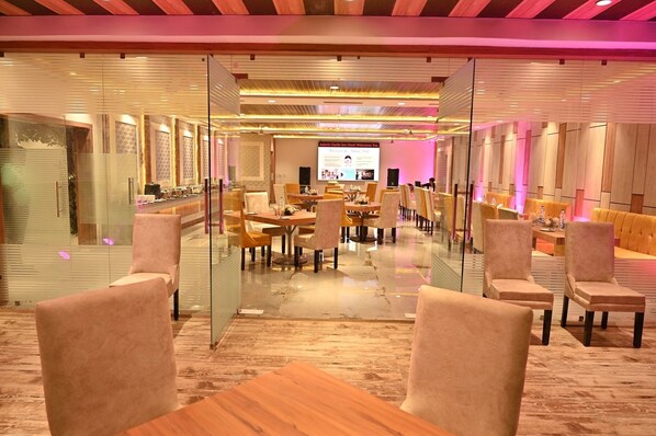 A modern conference room with glass partitions, wooden tables, and comfortable chairs. - Hotel Aakriti Clarks Inn Express (Bareilly)