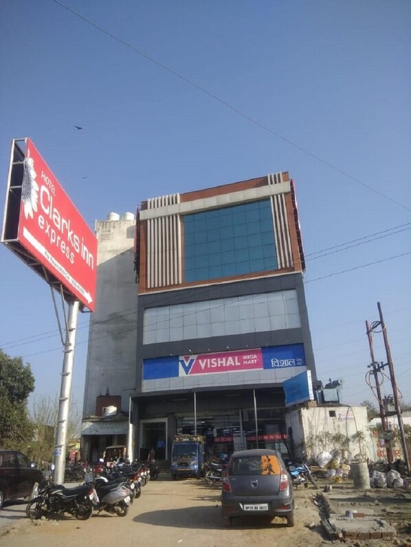 A hotel with a large sign for Hotel Clarksin and a Vishal Mega Mart store on the ground floor. - Hotel Aakriti Clarks Inn Express (Bareilly)