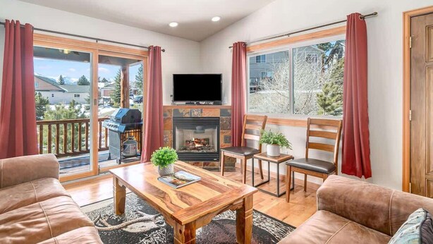 A cozy living room with a fireplace, comfortable seating, and a balcony with a grill. - Longs Peak Lodge; An Easy walk to downtown! #3221 (Estes Park)