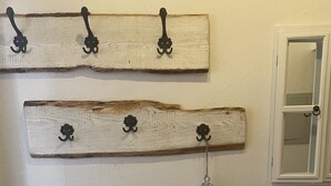 A wall-mounted wooden rack with hooks and a decorative key.