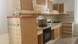 A kitchen with wooden cabinets, a microwave, and a stove.