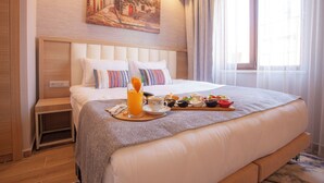 A hotel room with a large bed, a bedside table, a painting on the wall, and a window with curtains. - Old Town Point Hotel & Spa Antalya (Antalya)
