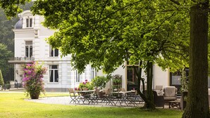 En stor, elegant bygning med en velholdt have og udesiddeplads.