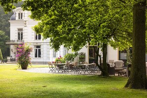 A large, elegant building with a well-maintained garden and outdoor seating area. - B&B and SPA Estate Matanze, terrace room (Terwolde)