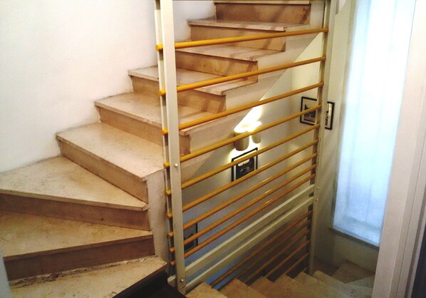 Eine Treppe mit Metallgeländer und einer Lampe am unteren Ende.
