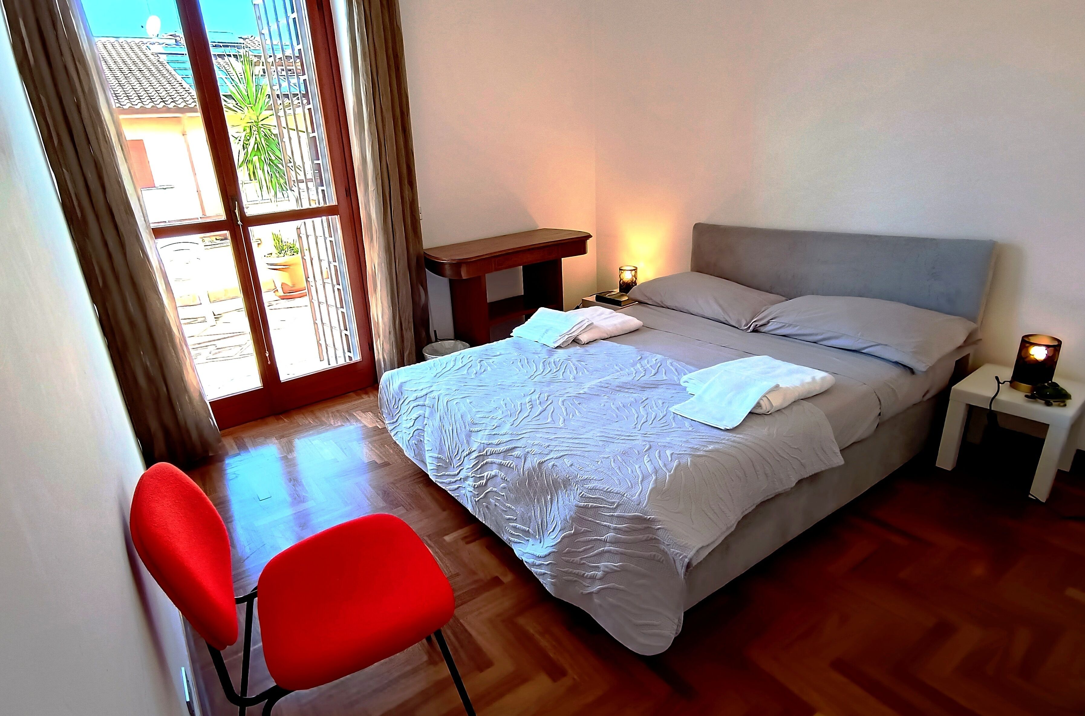 Une chambre à coucher avec un lit, une table de chevet, une lampe et une chaise.
