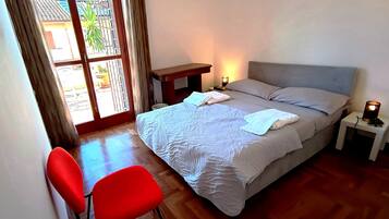 Une chambre à coucher avec un lit, une table de chevet, une lampe et une chaise.