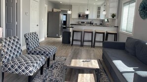 Una cocina moderna con armarios blancos, una isla central e iluminación colgante.