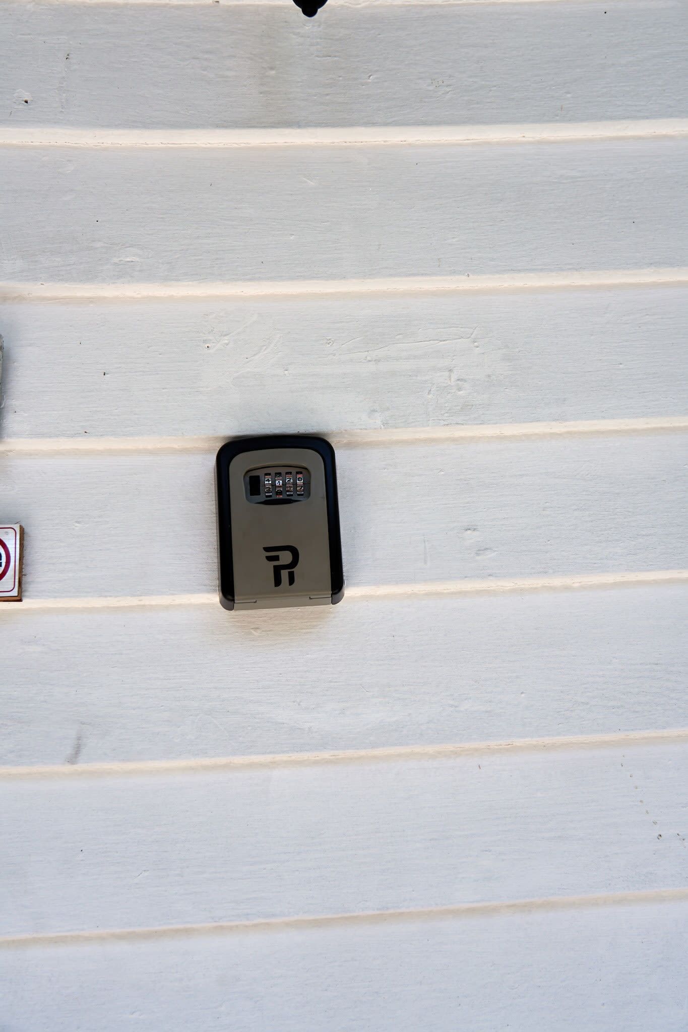 A parking meter on a white wall with horizontal lines.