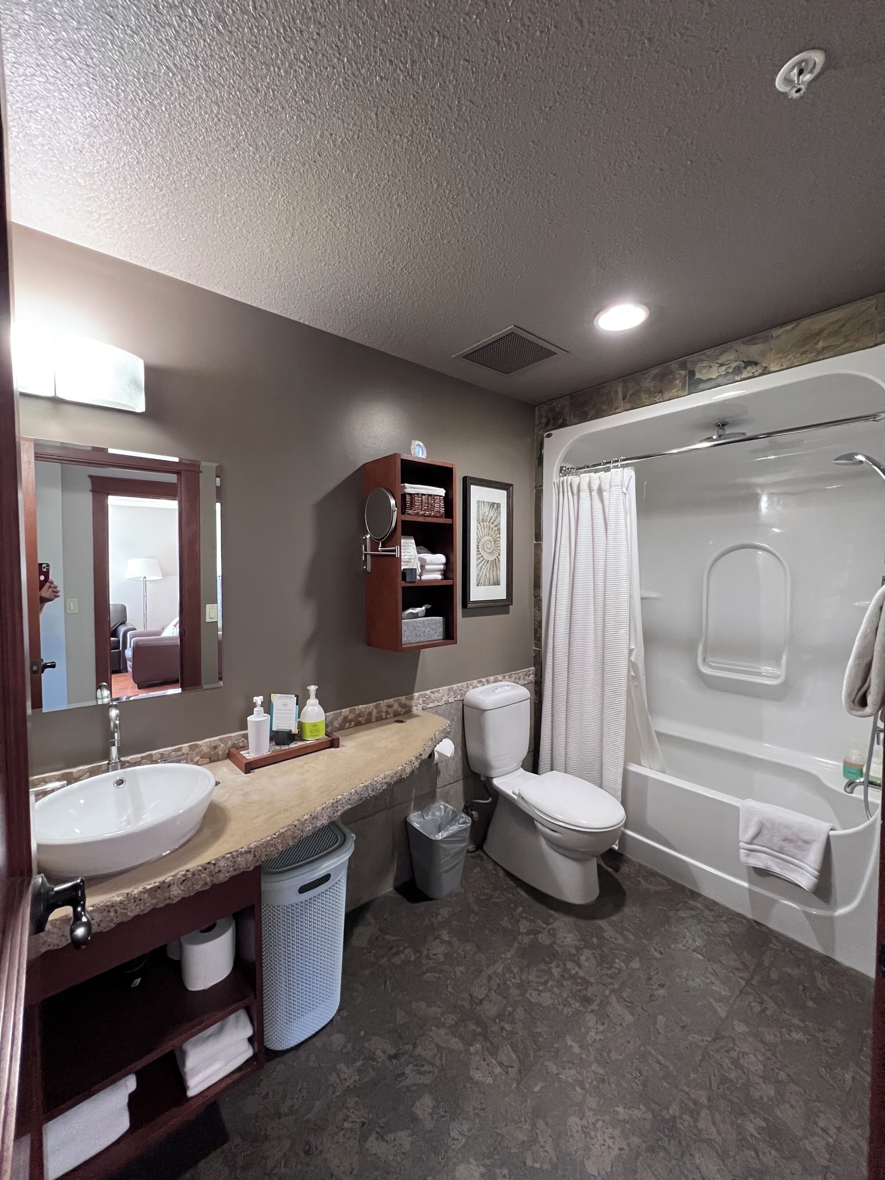 A modern bathroom with a sink, toilet, and bathtub.