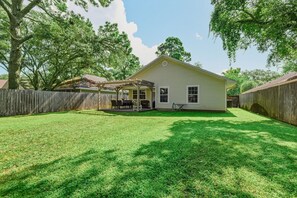 A single-story house with a covered patio and a fenced backyard.