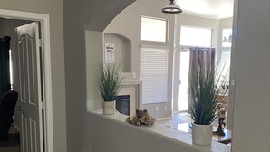 A hallway with a white door, a fireplace, and potted plants. - 15 minutes to strip !!! Vegas getaway (N las vegas)