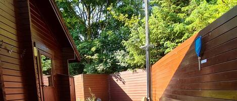 A hot tub in a wooden deck area with a red canopy overhead.