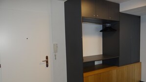 Una stanza con una porta bianca, un armadietto in legno e una libreria scura.