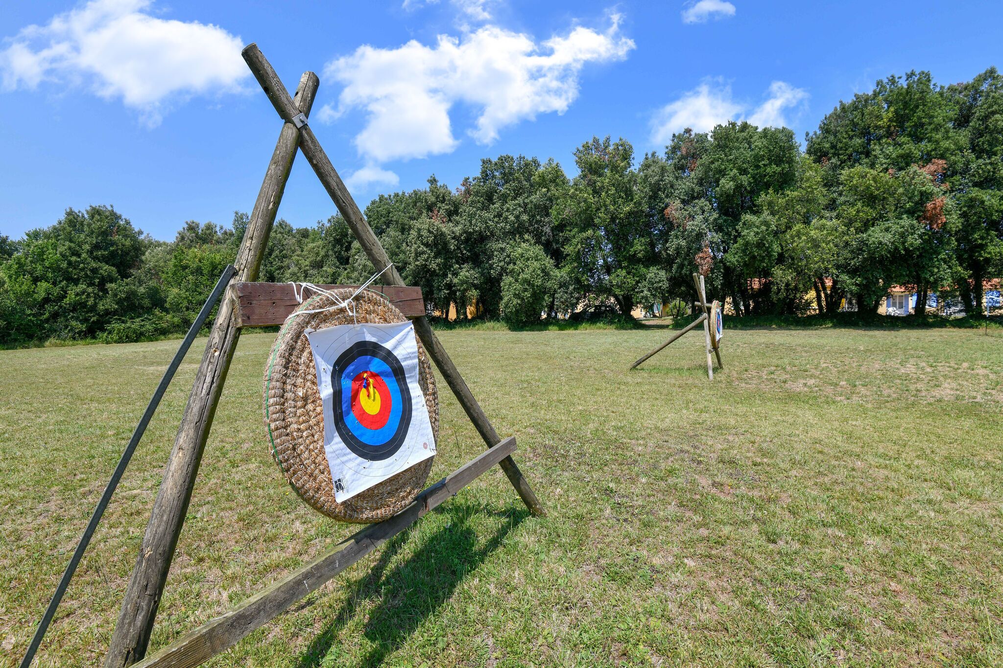An outdoor target practice area with a wooden archery setup.