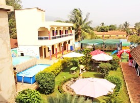 Un patio con piscina, mobiliario de exterior y zona de juegos infantiles.